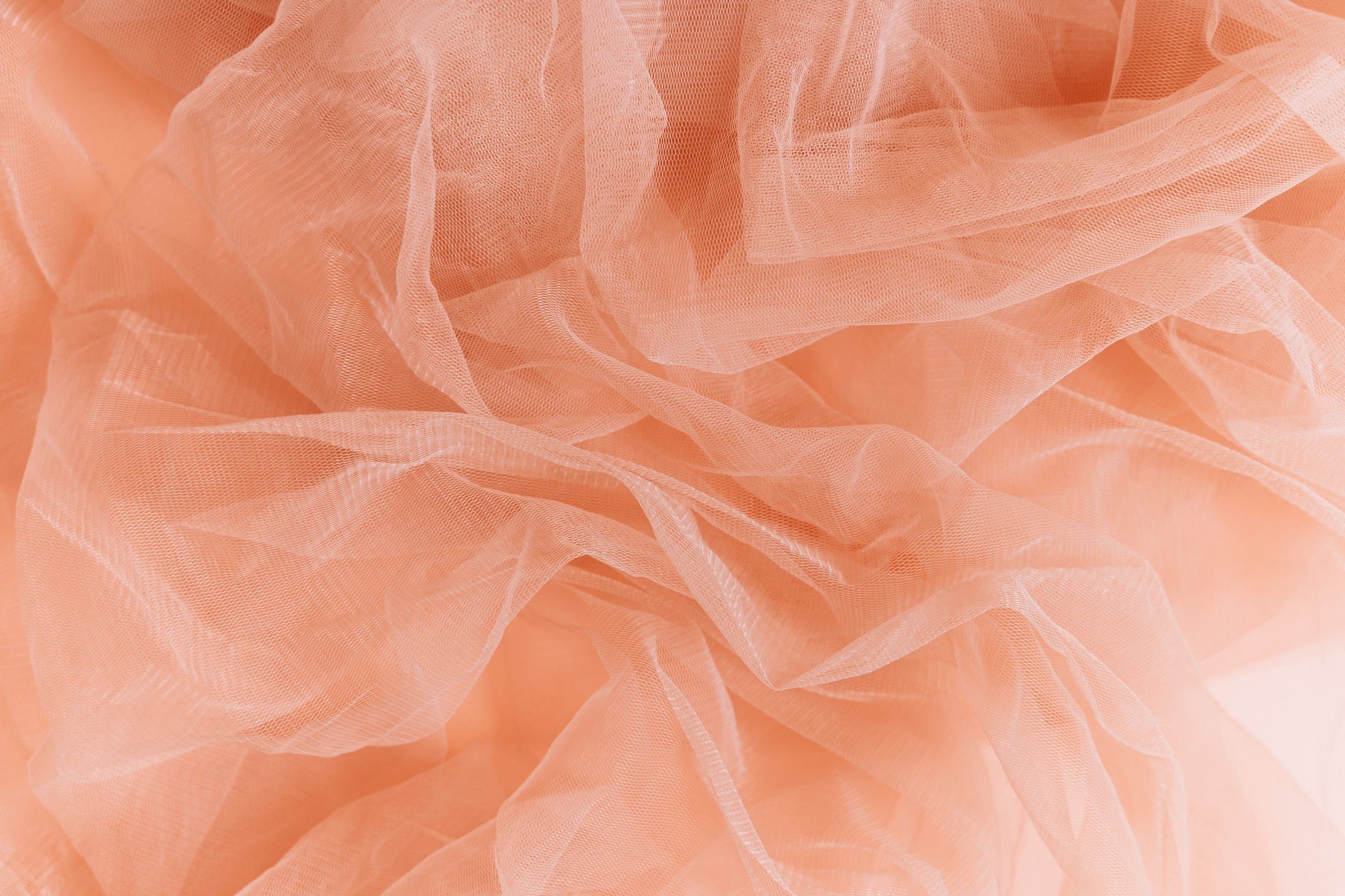 A close view of crumpled peach tulle